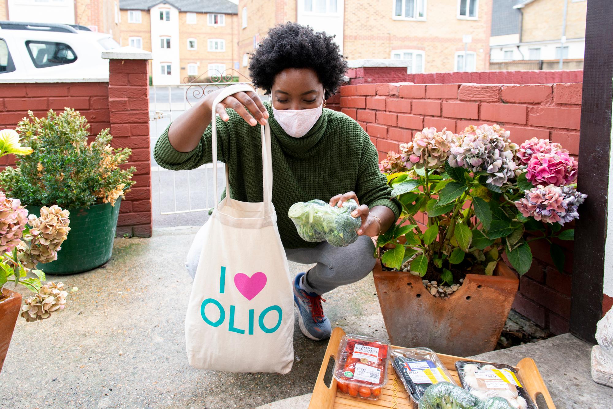 An Olio 'Food Waste Hero' drops food off with a neighbour.