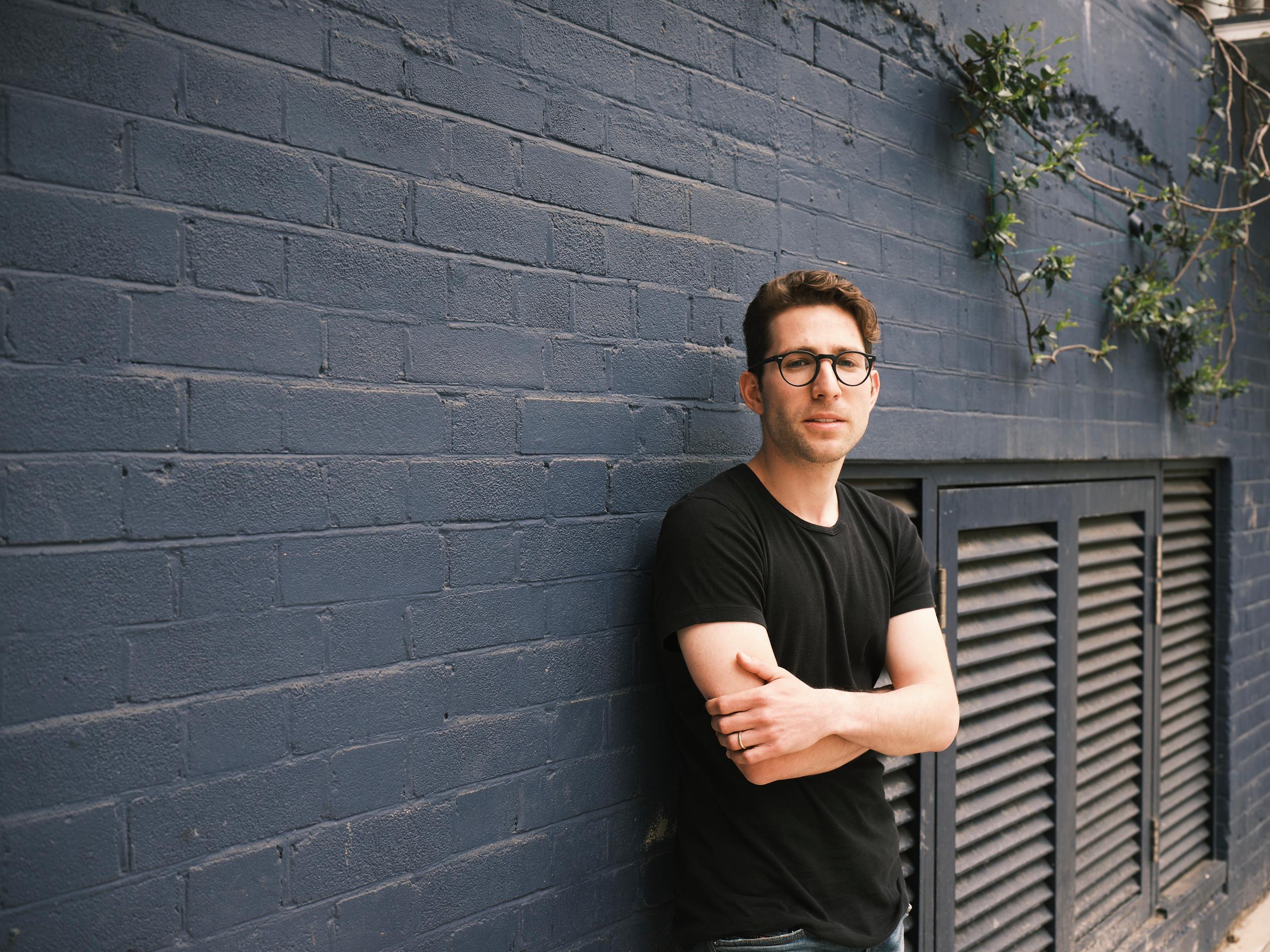 a landscape photo of Ziv Reichert, partner at LocalGlobe, standing against a grey wall.