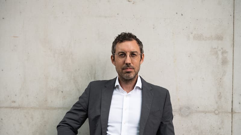 Daniel MacGregor, one of the cofounders of Nexxiot, standing against a white wall