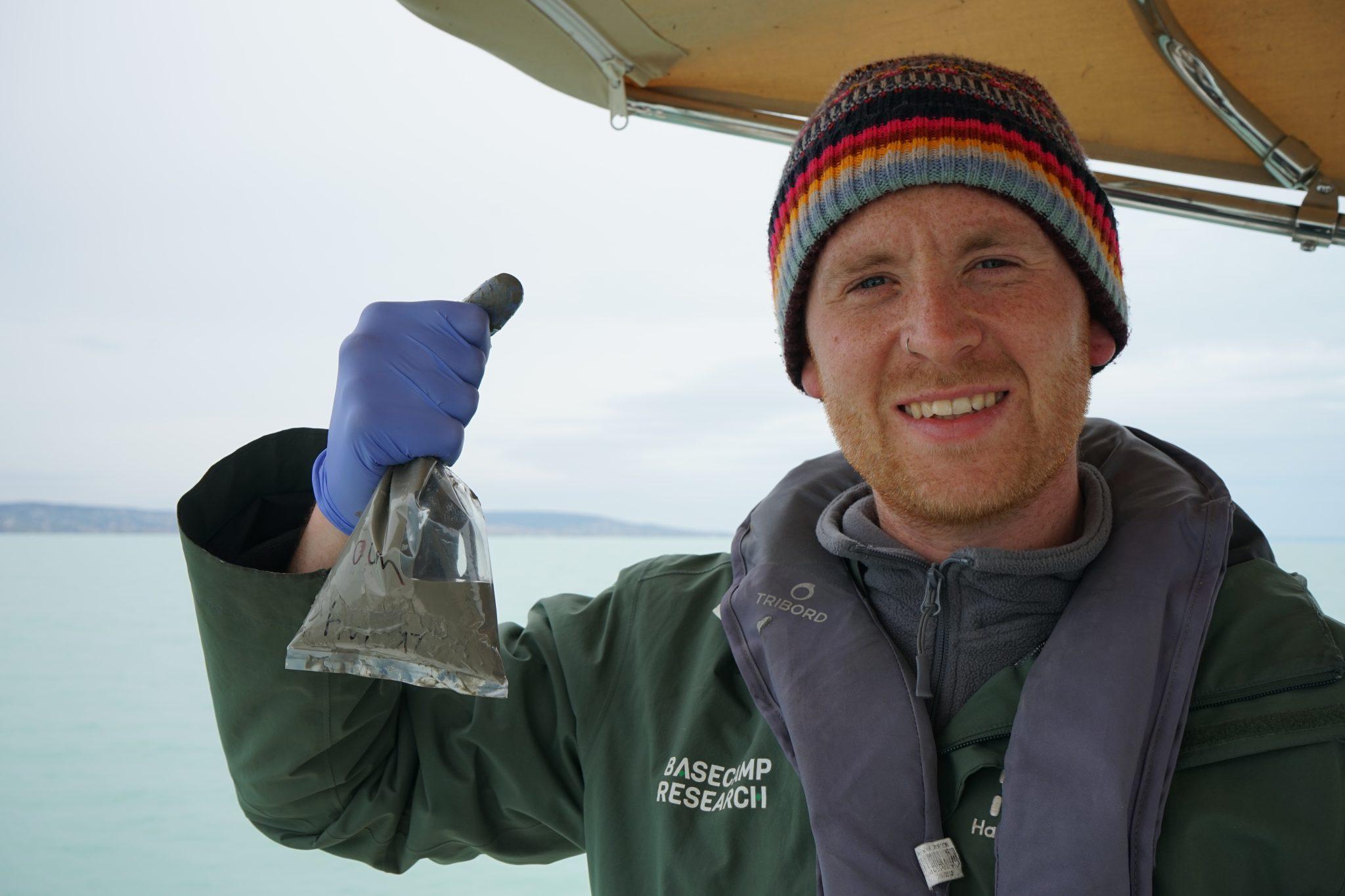 Basecamp's Marlon Clark holds up a sample bag containing sediment and water samples from Lake Balaton.