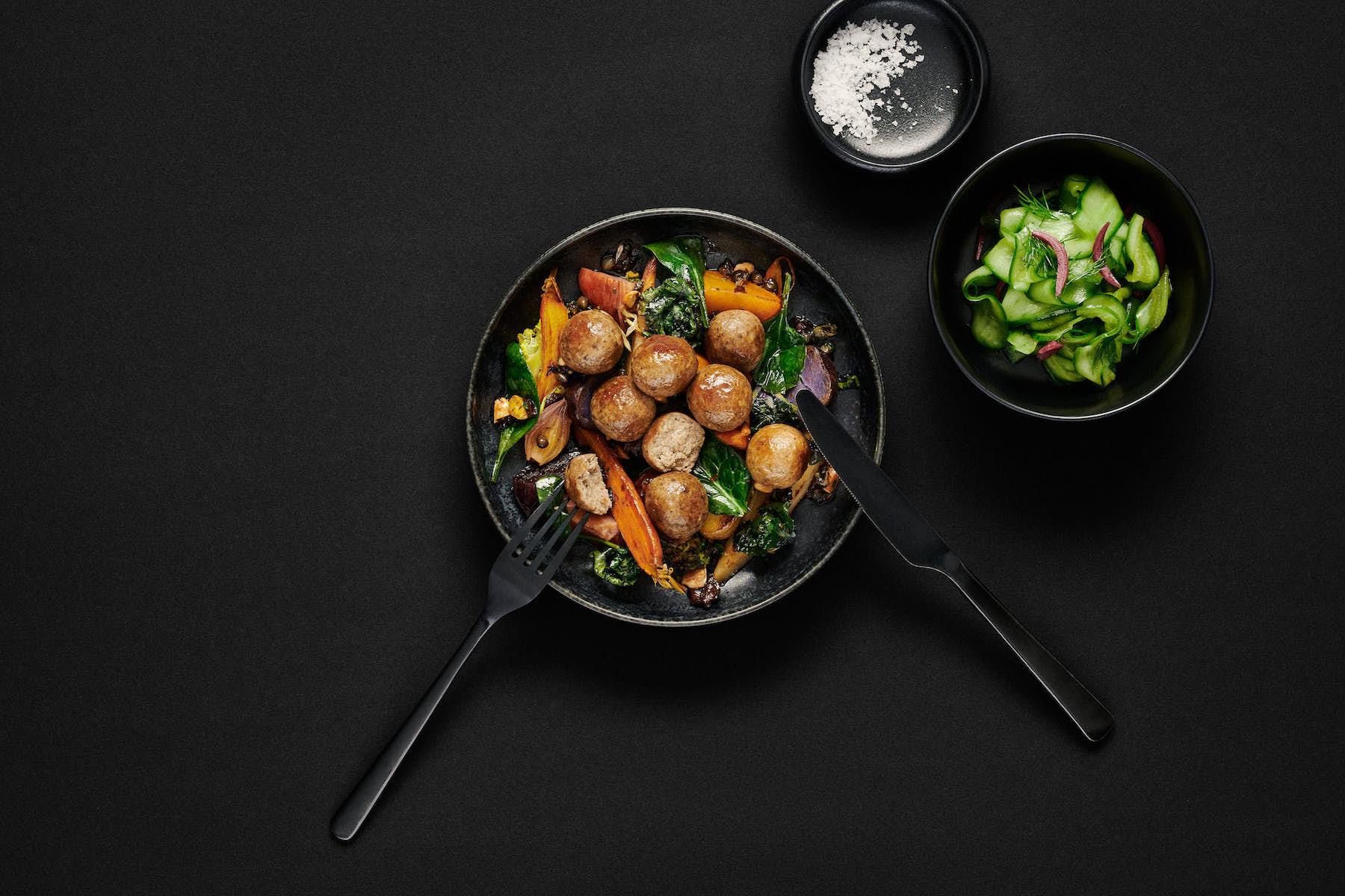 Infinite Roots Meatballs cooked on a plate and a dark background