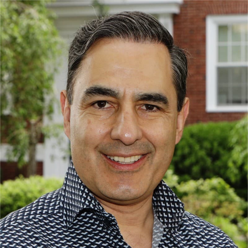 A close-up photo of Luis Valdich with some trees and bushes in the background.