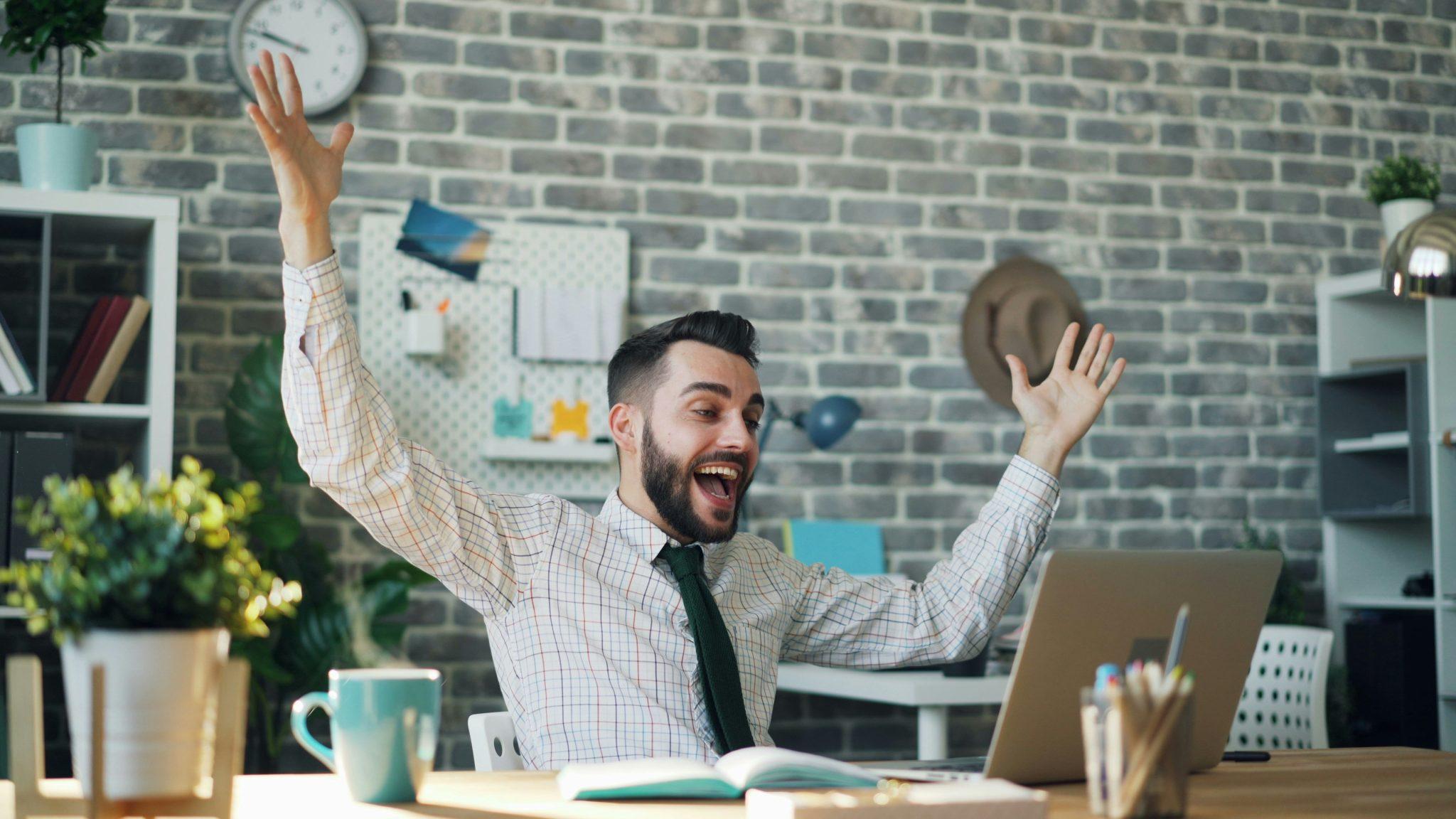 man cheering at laptop Unsplash