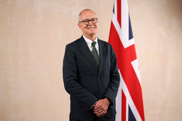 UK science minister Patrick Vallance standing beside a union jack.