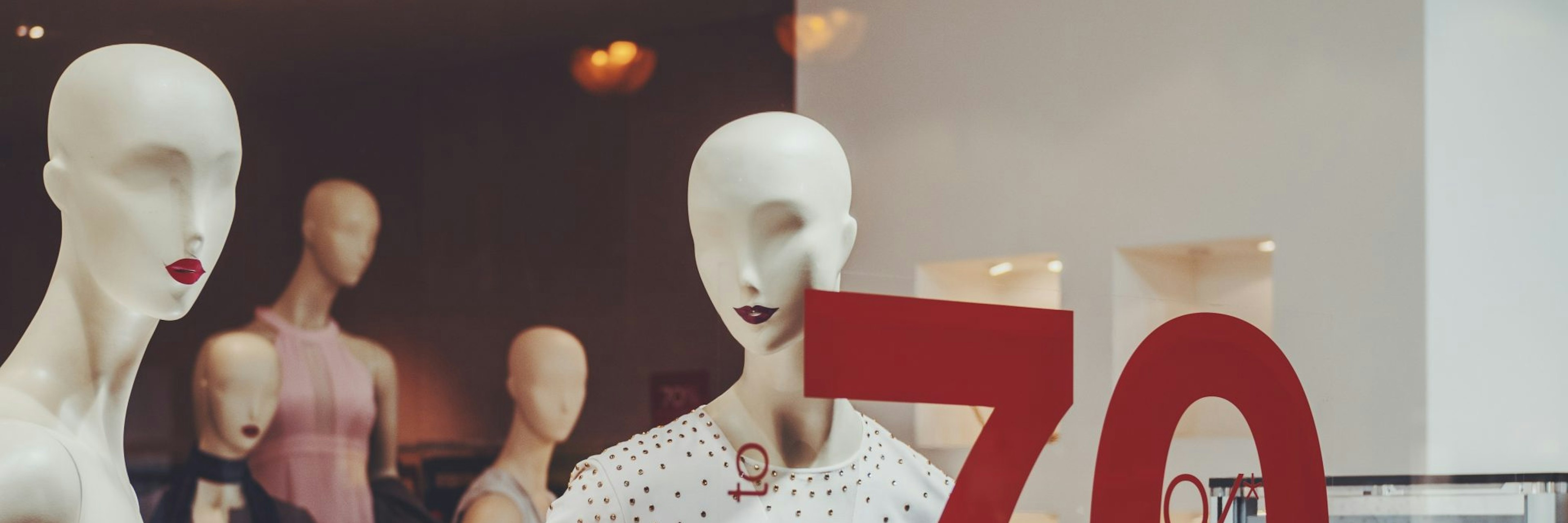 Mannequins in shop window with sale sign