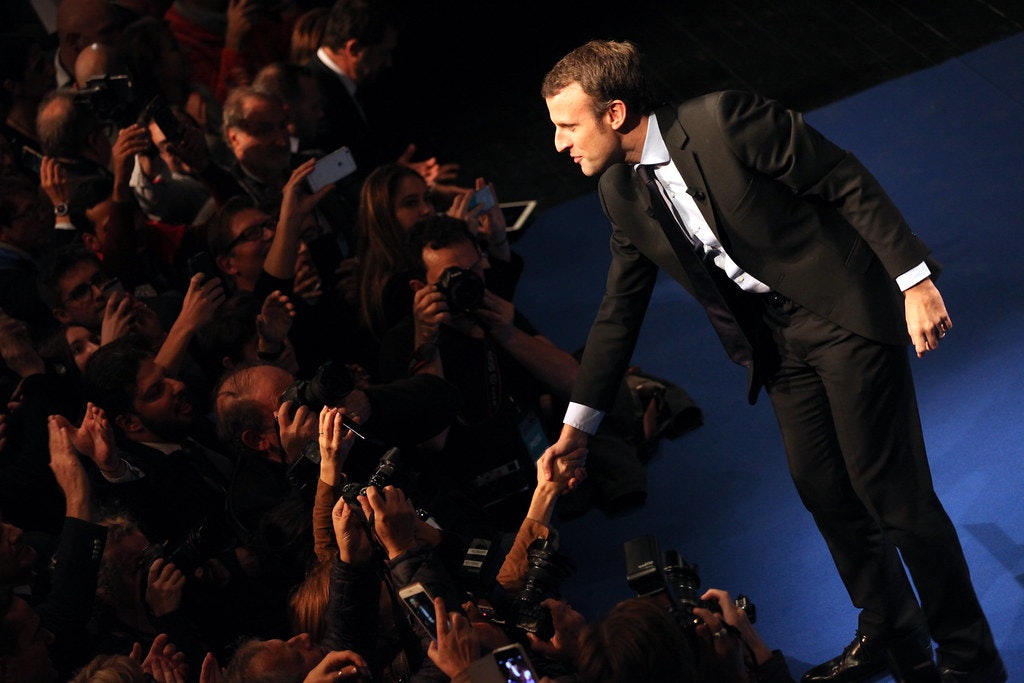 A photo of French President Emmanuel Macron greeting a crowd.