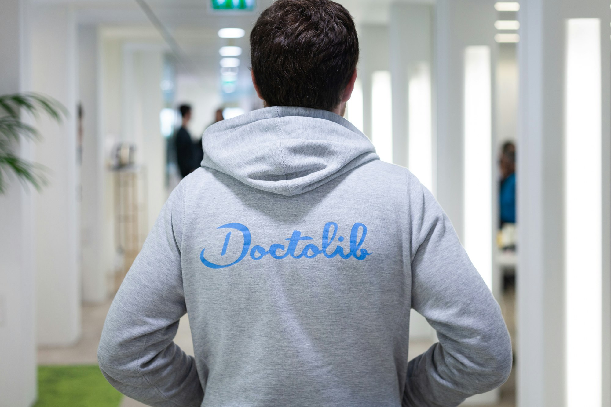 A photo of a man wearing a hoodie with the Doctolib logo