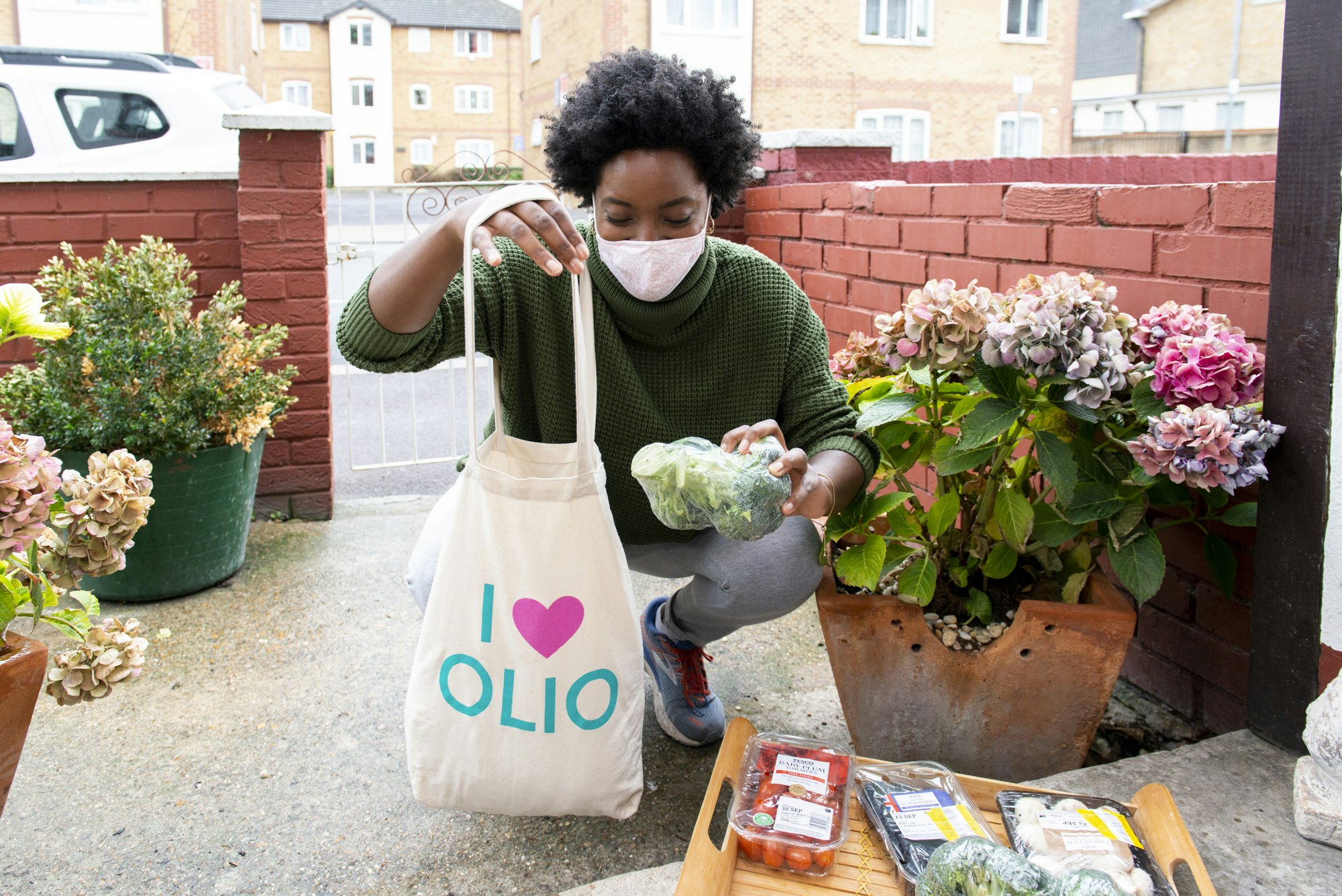 An Olio 'Food Waste Hero' drops food off with a neighbour.
