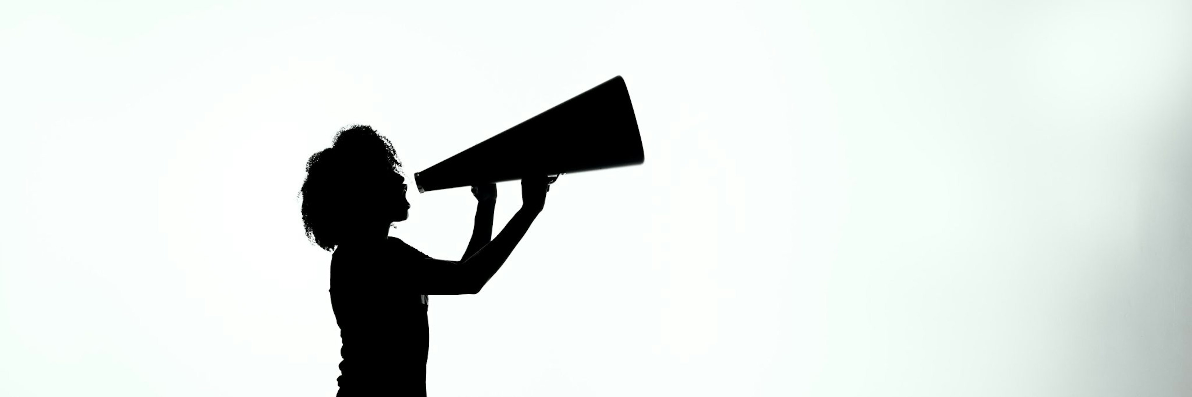 Silhouette of woman shouting into megaphone