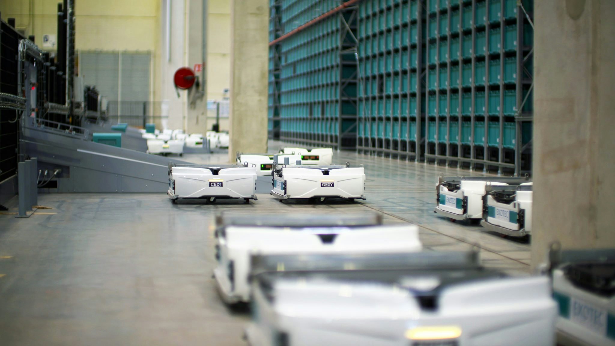 An image of Exotec Skypod robots, which are short and white with a wide square top, in a warehouse