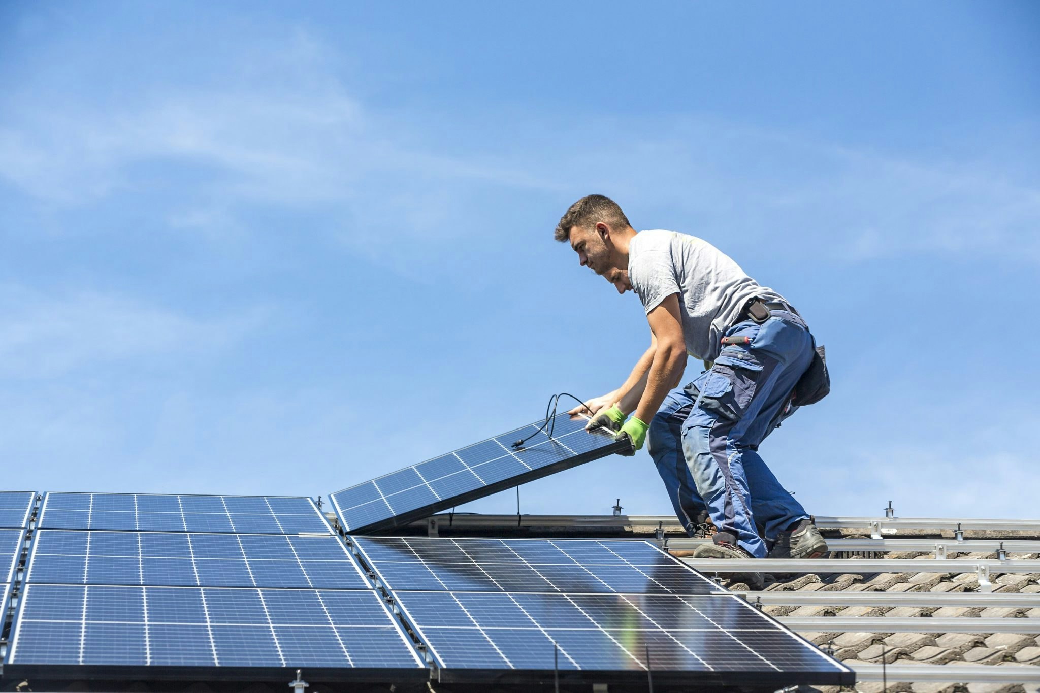 An Enpal PR photo of two men installing solar panels on a roof