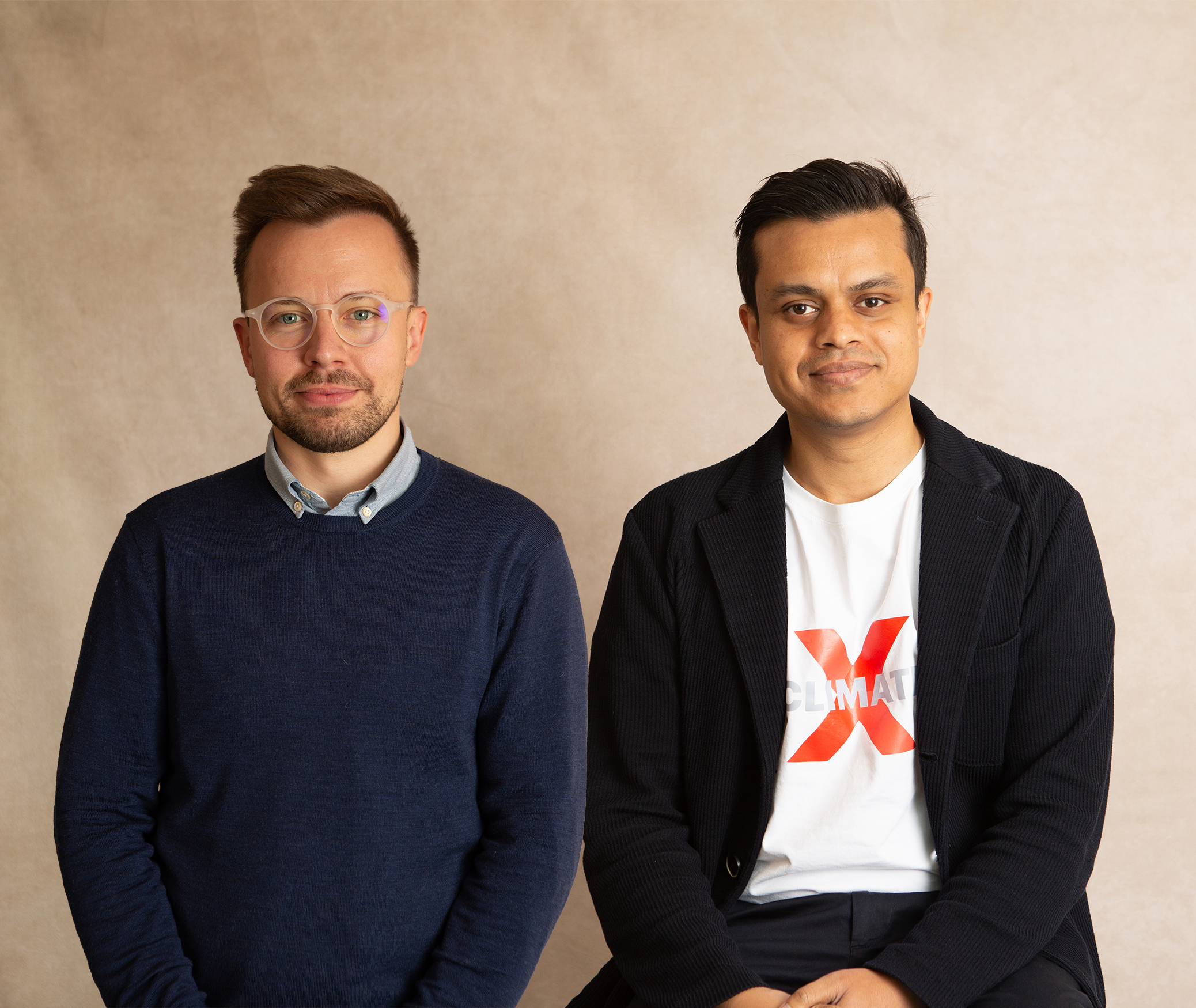 Two men next to each other, one weaaring a shirt and jumper, the other a T-shirt and cardigan