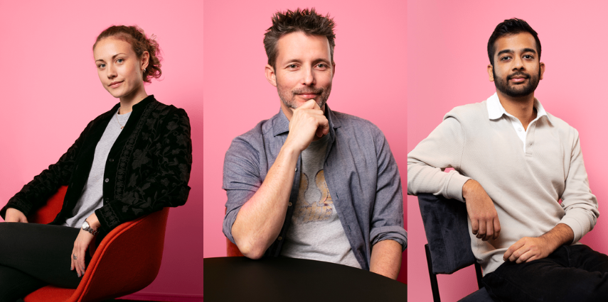 Men and women sitting against a pink background