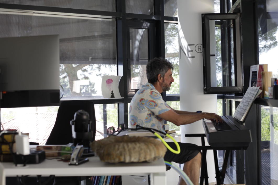 An image of Starlab's Giulio Rufini playing piano in his office.