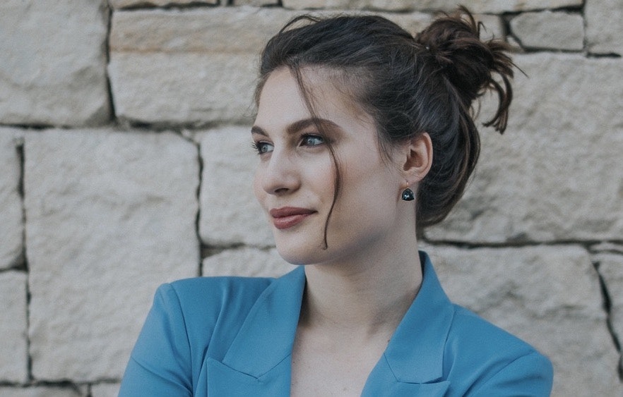 An image of Konstantina Psoma, cofounder and CEO of Kaedim, one of Sifted's under the radar Greek startups to watch. She's wearing a blue blazer, and has her, which is brown, hair tied up