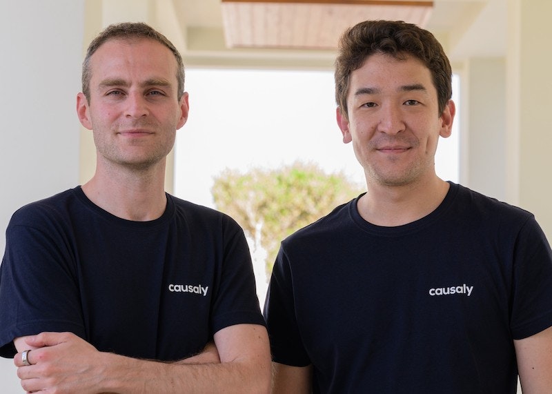 An image of Yiannis Kiachopoulos and Artur Saudabayev, cofounders of greek startup Causaly. They are both wearing black tee-shirts emblazoned with the Causaly company logo.
