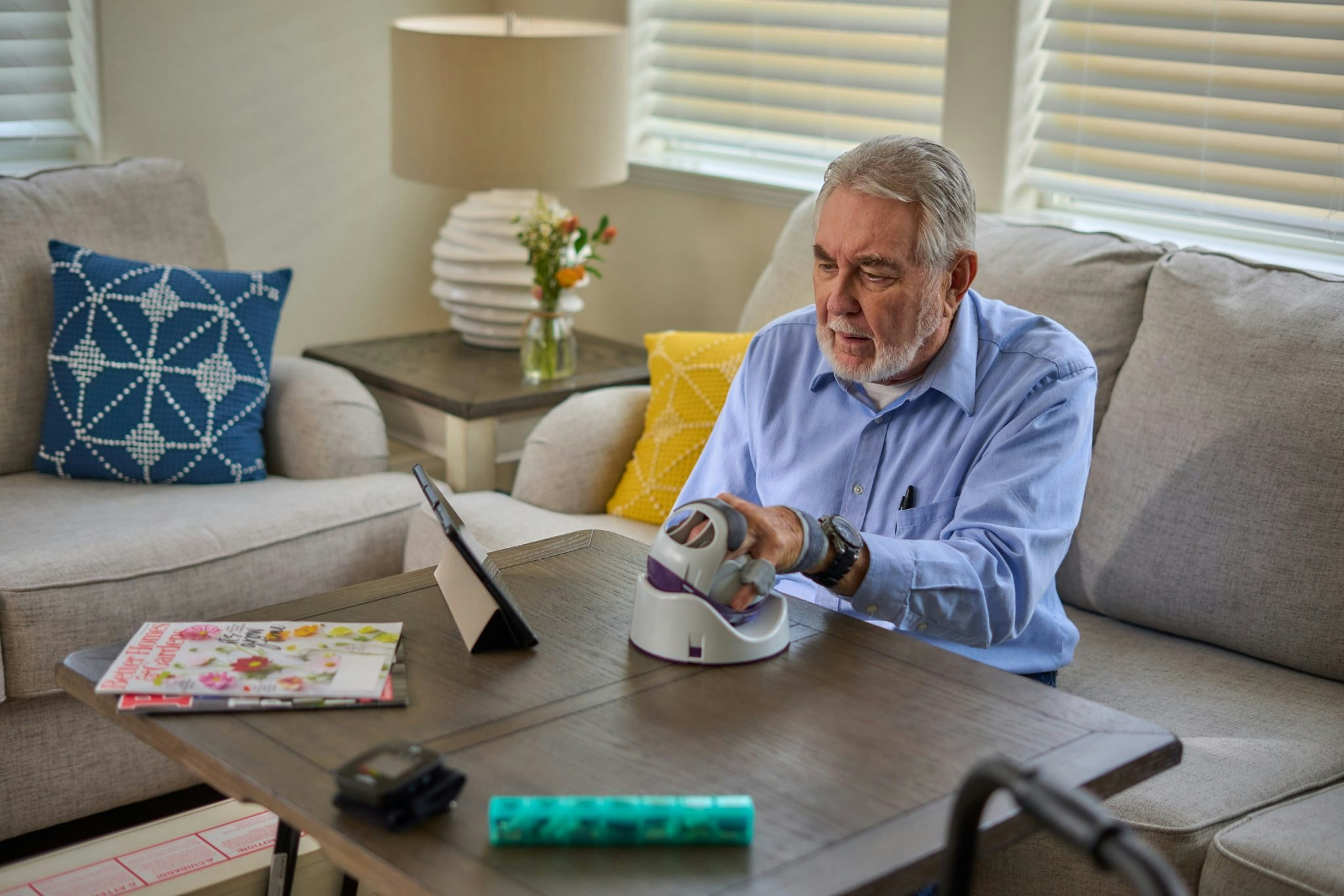 An elderly man using Neurofenix's handheld rehabilitation device
