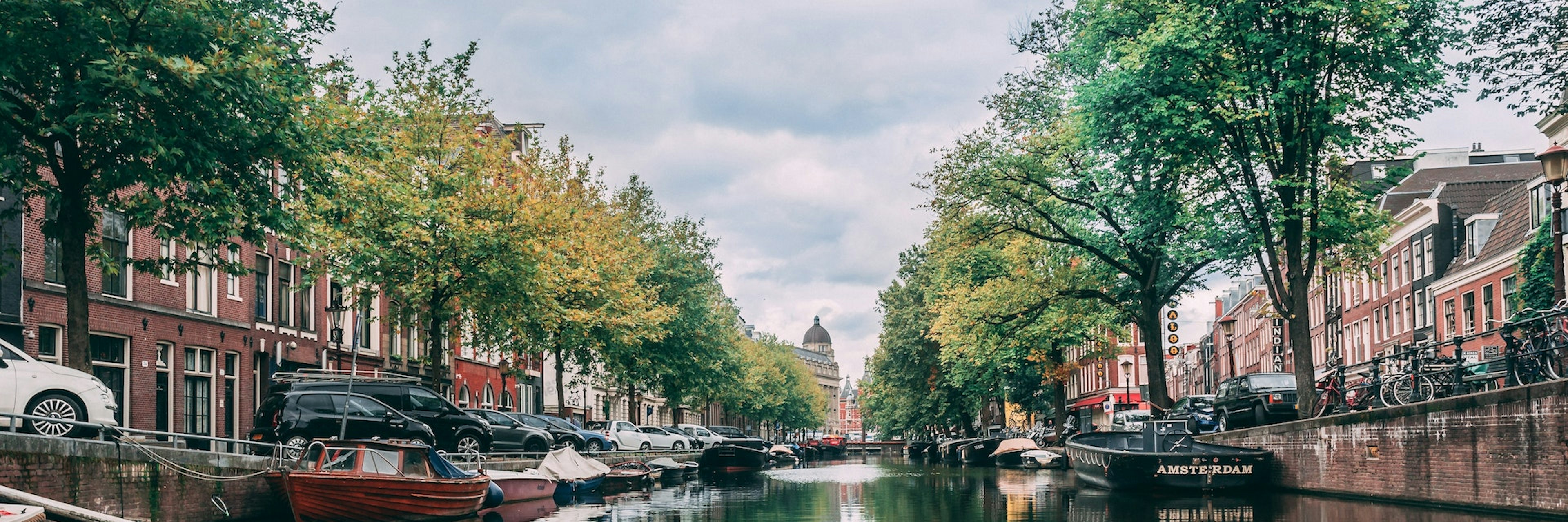 A cityscape of a house-lined canal in Amsterdam