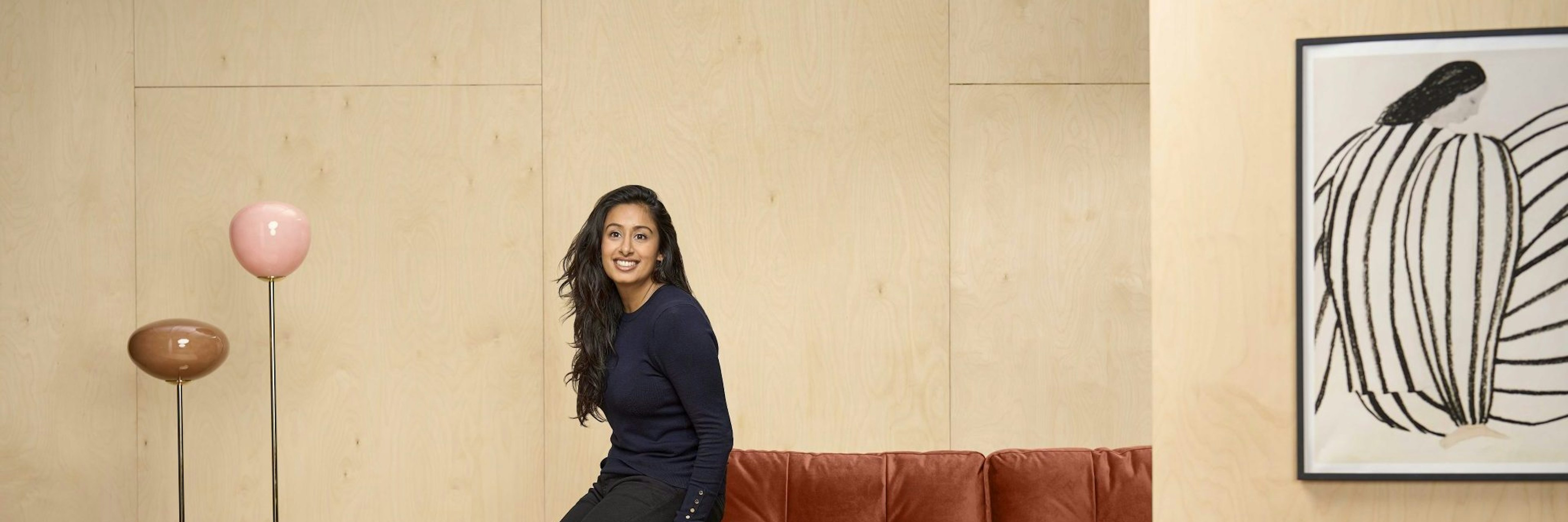 An image of COO of Trouva Dimple Patel leaning on a sofa