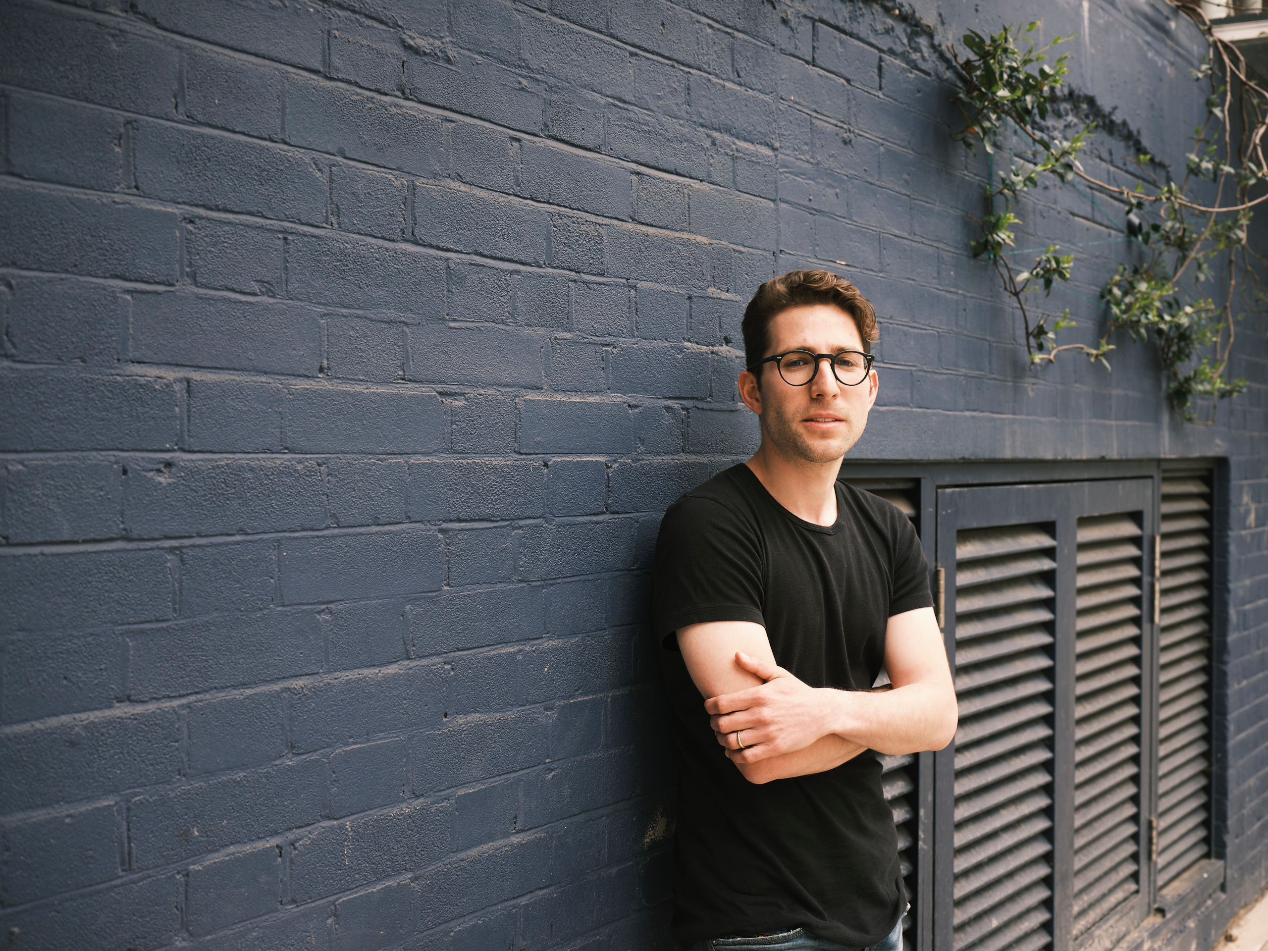 a landscape photo of Ziv Reichert, partner at LocalGlobe, standing against a grey wall. 