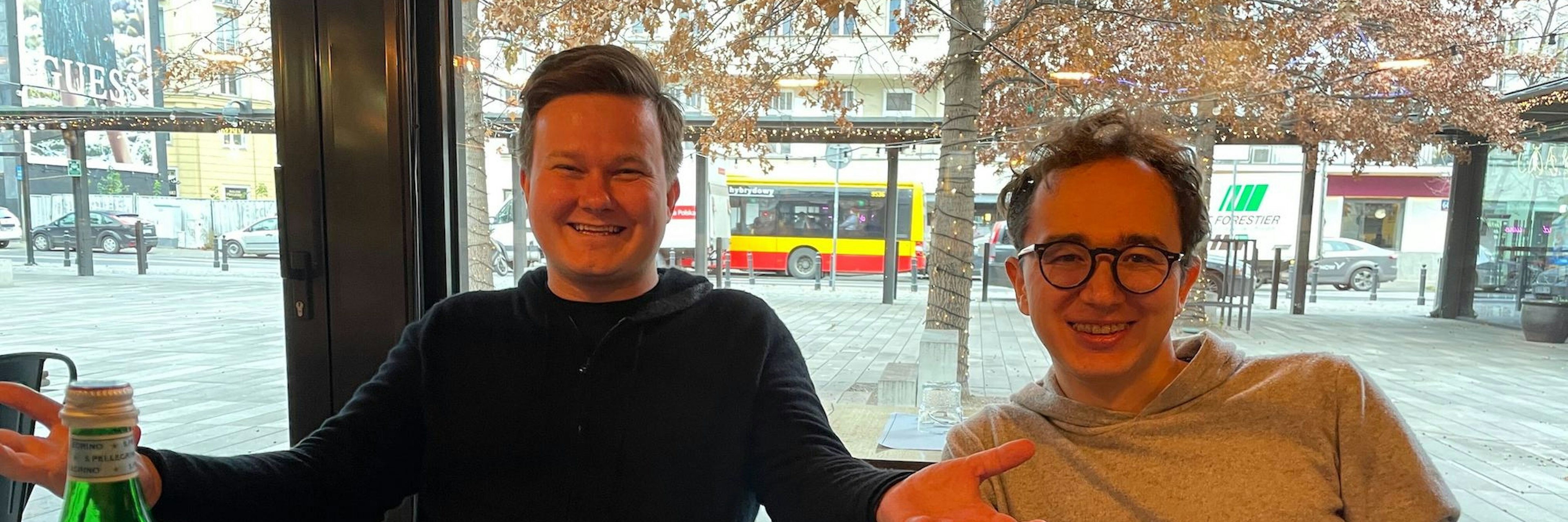 Ramp cofounders Szymon Sypniewicz and Przemek Kowalczyk at a restaurant in Warsaw, with plates of fish and chips in front of them
