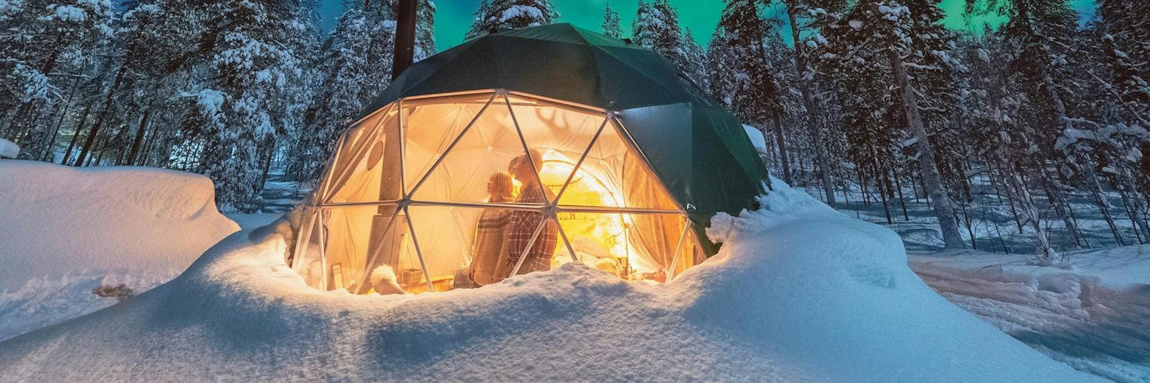 Picture of a tent in Finland with northern lights showing.