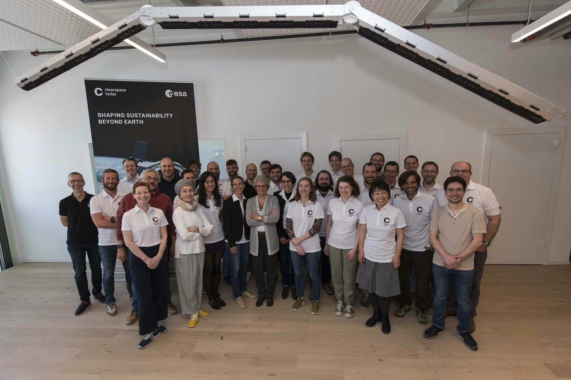 The ClearSpace team under a structure prototype of the capture system robotic arm_ full size