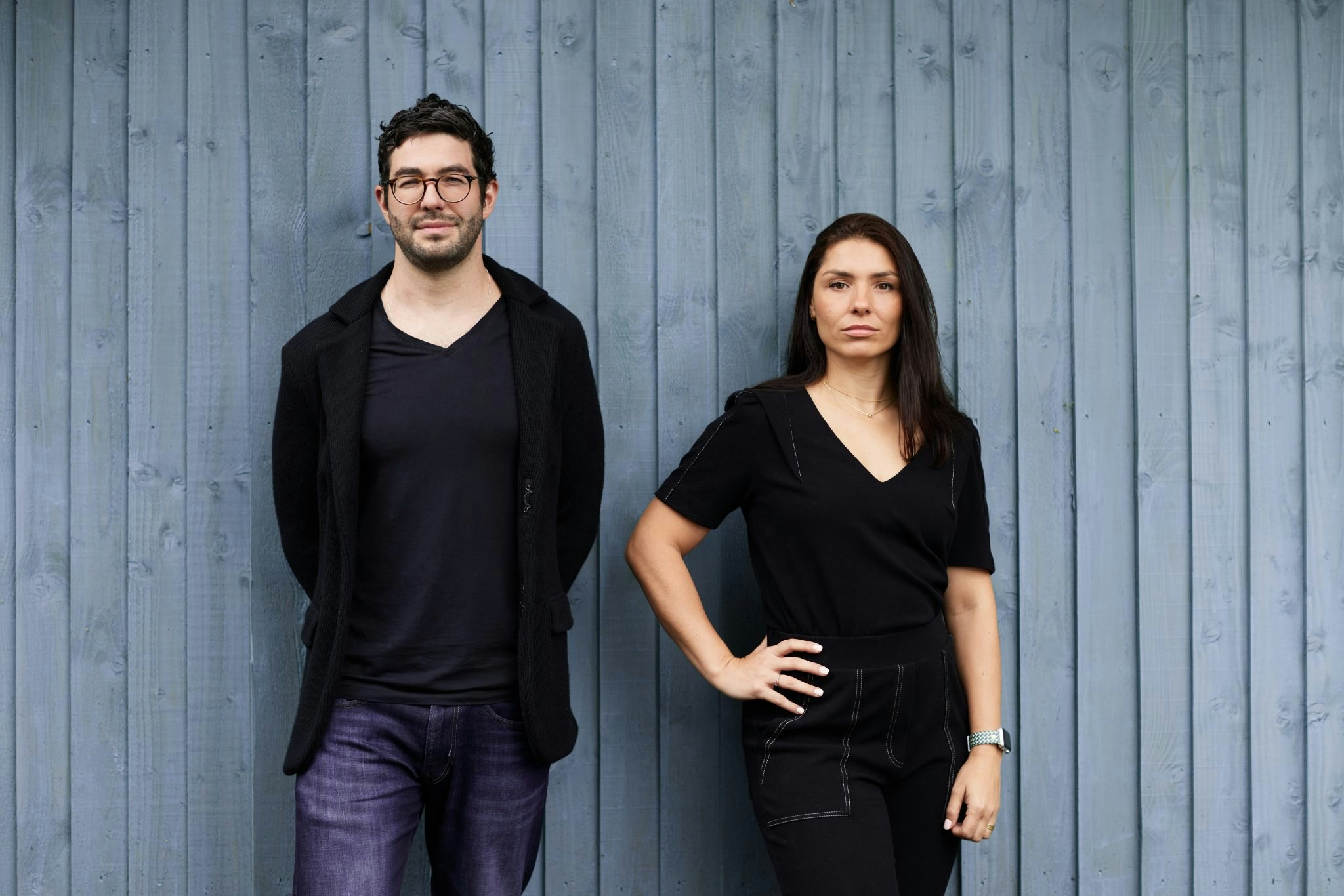 The cofounders of UJJI posing for a corporate shot against a charcoal coloured fence