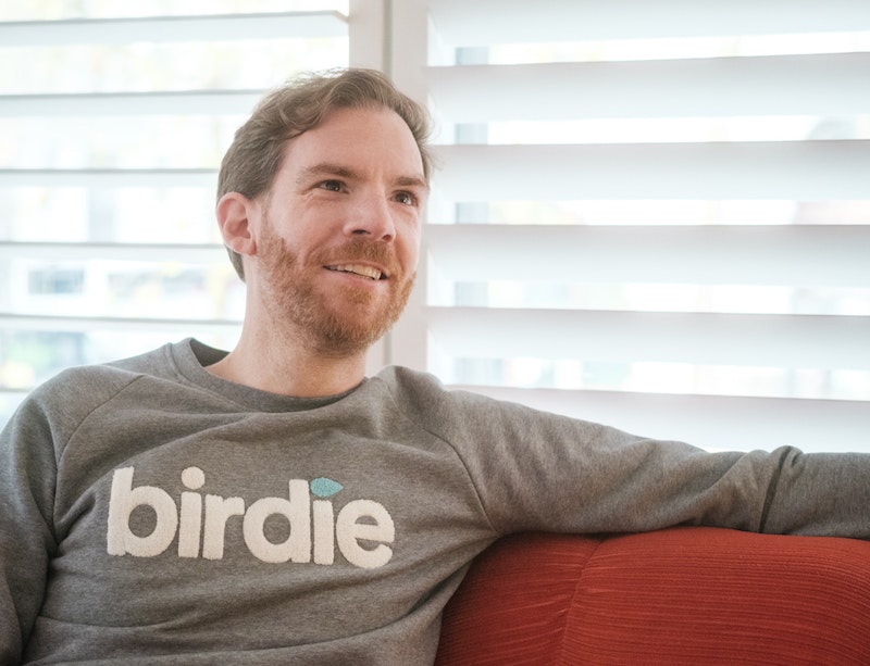 Gwen Le Calvez, CTO of Birdie, sitting on a red sofa