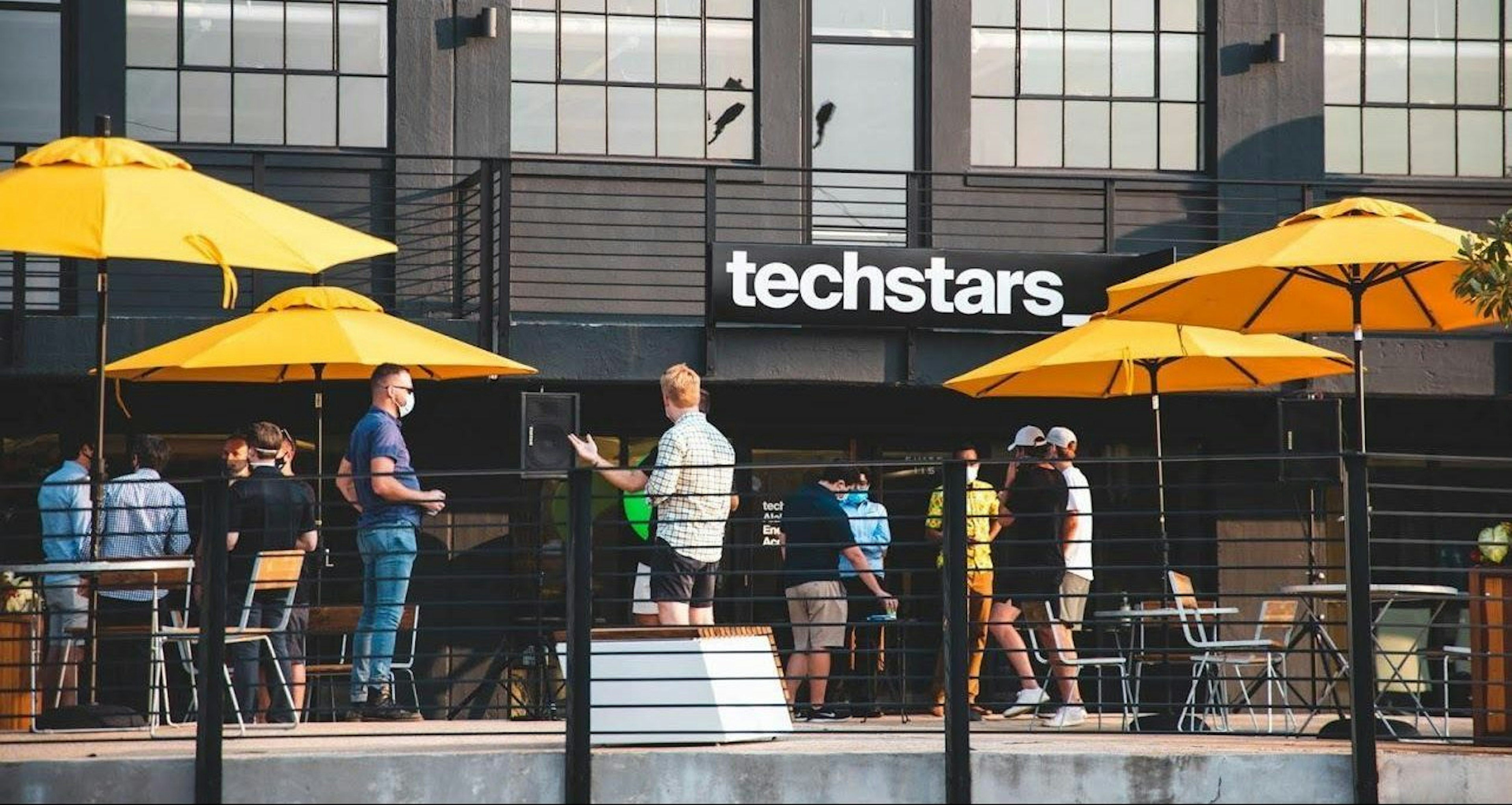 Picture of people standing in an outside area of a Techstars building.