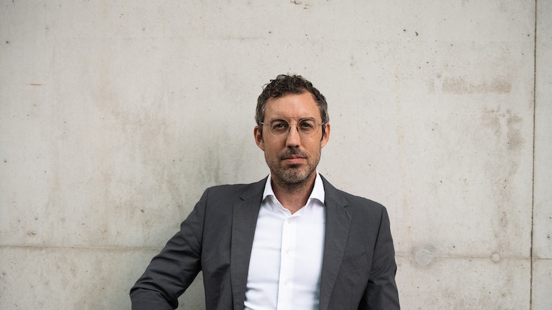 Daniel MacGregor, one of the cofounders of Nexxiot, standing against a white wall