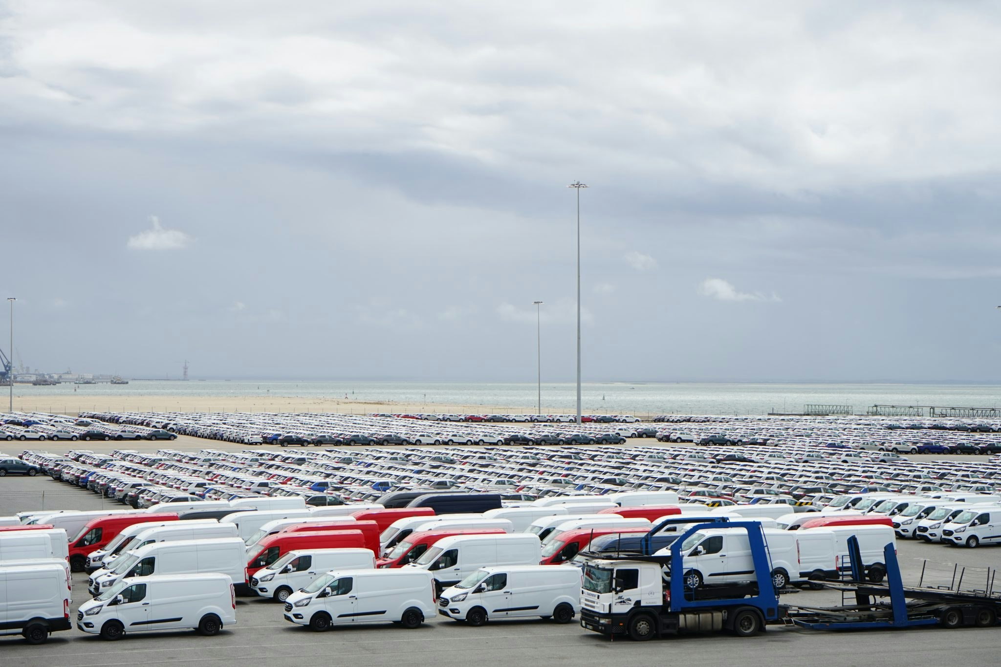 An image of thousands of newly built cars and vans parked in front of the sea at Setubal port