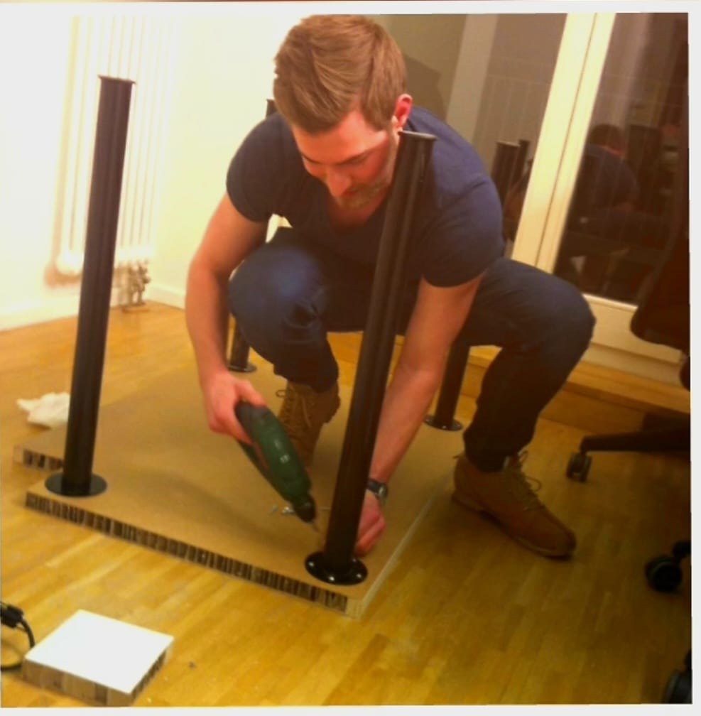 a photograph of Weber drilling the legs onto a desk in N26's first office