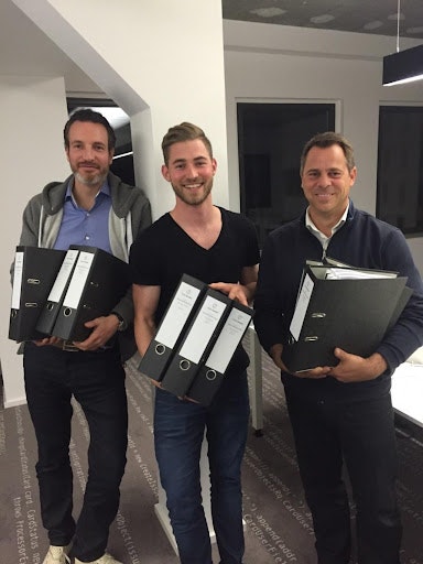 Three men holding binders