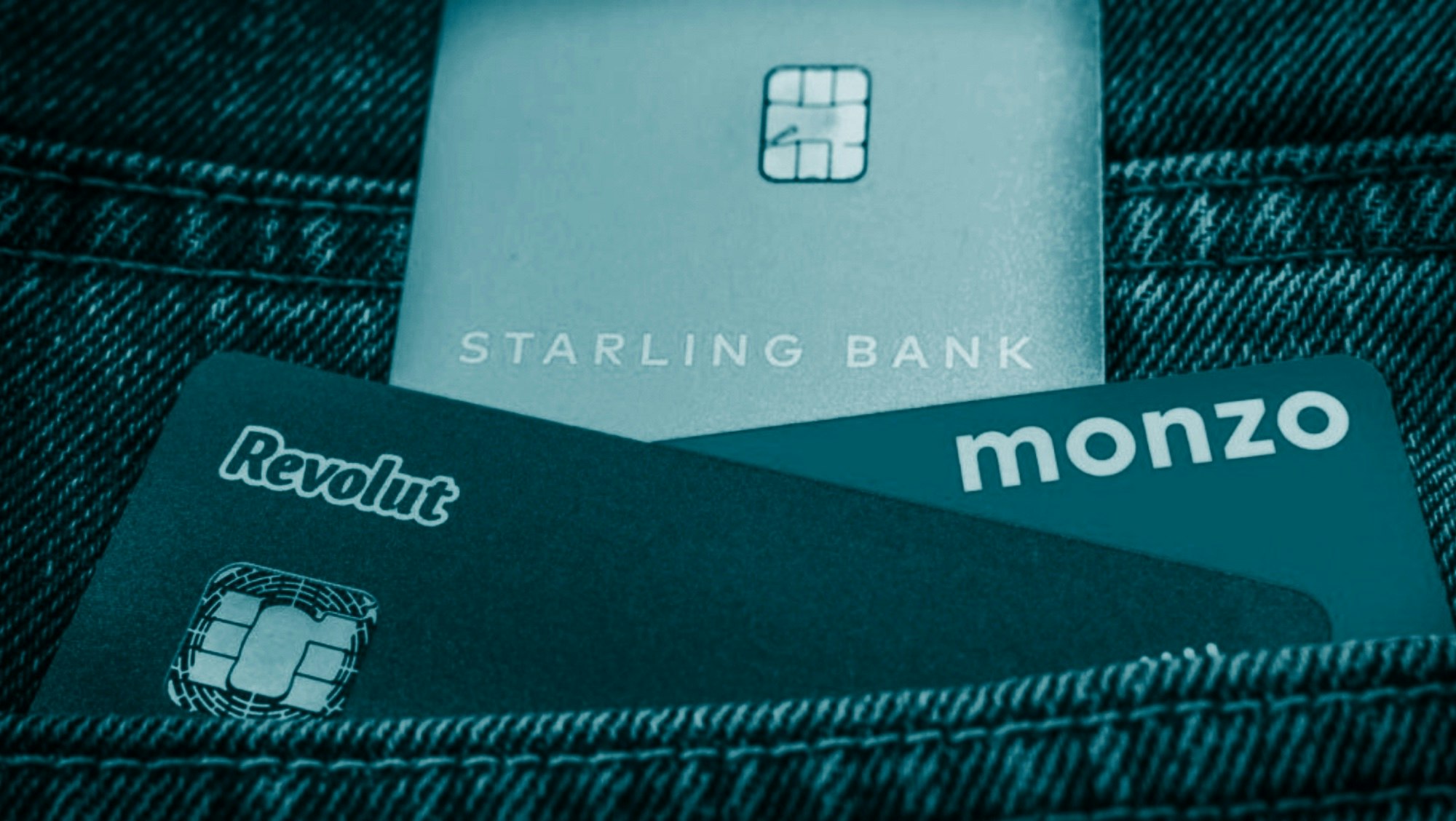 Image of a Revolut, Monzo and Starling card in the back pocket of a pair of jeans.