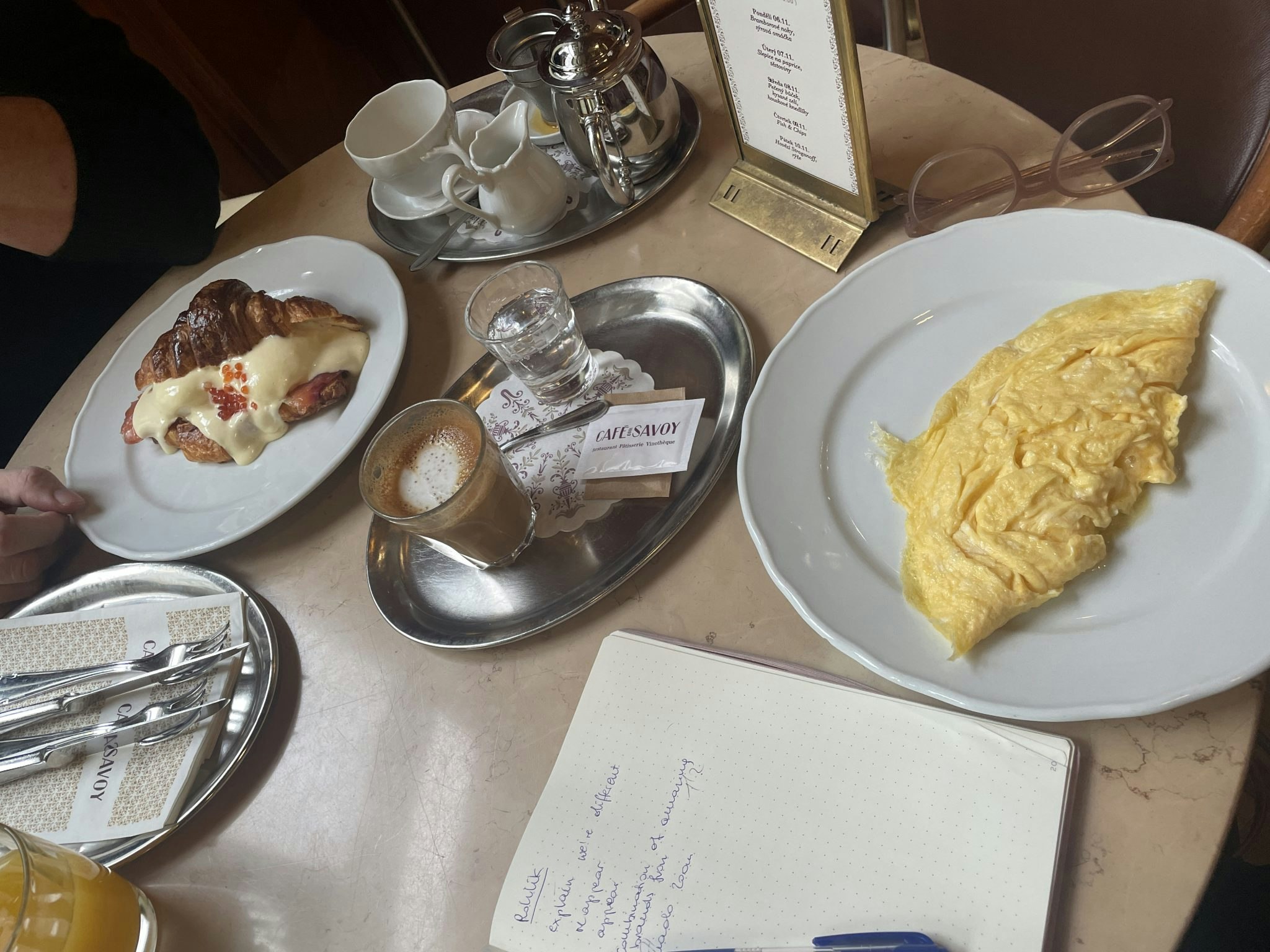 A picture of a table at the Cafe Savoy, showing an omelette, a croissant and tea and coffee.