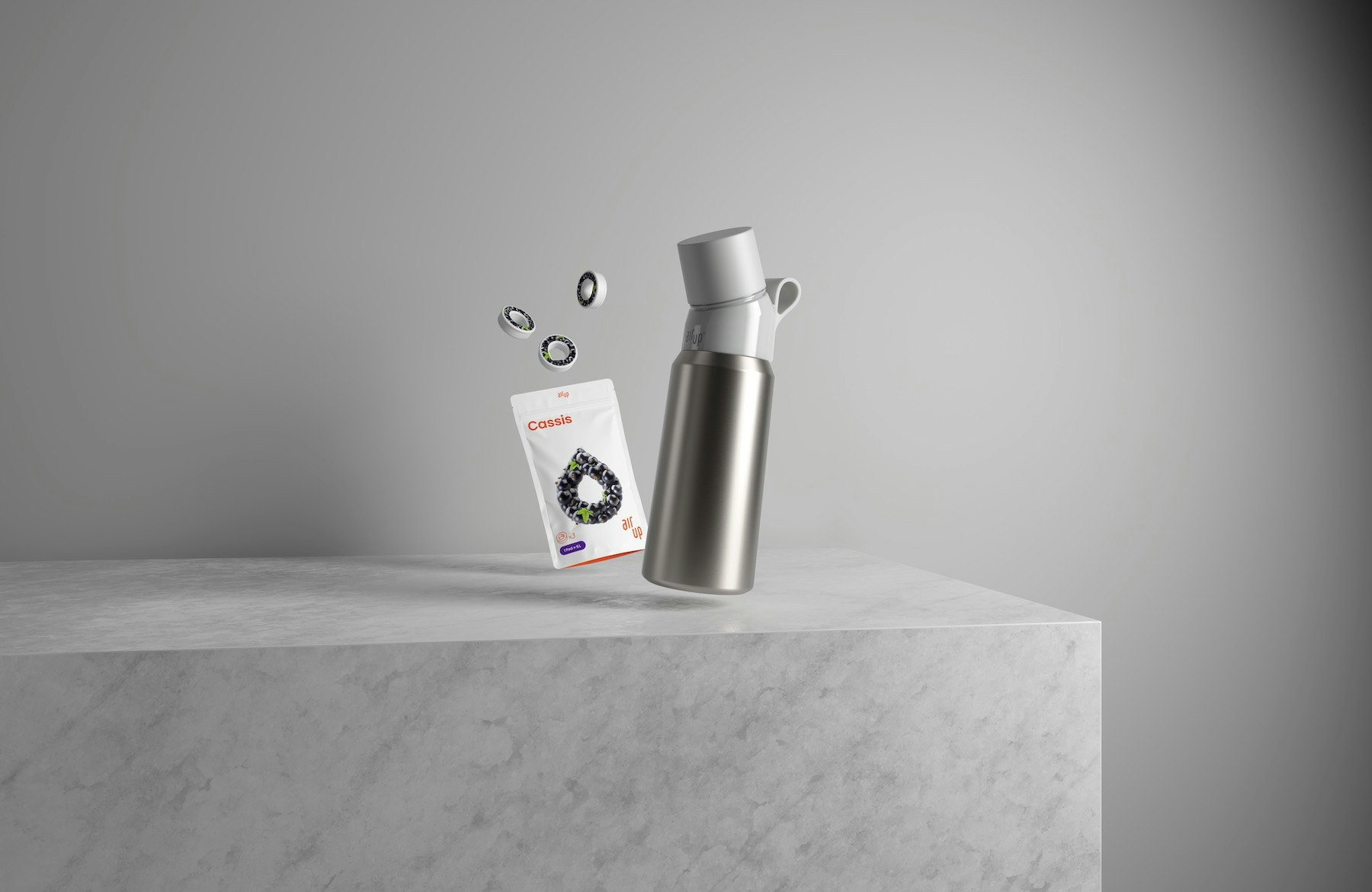 A photo of a black and silver air up bottle and pods on a grey table and background