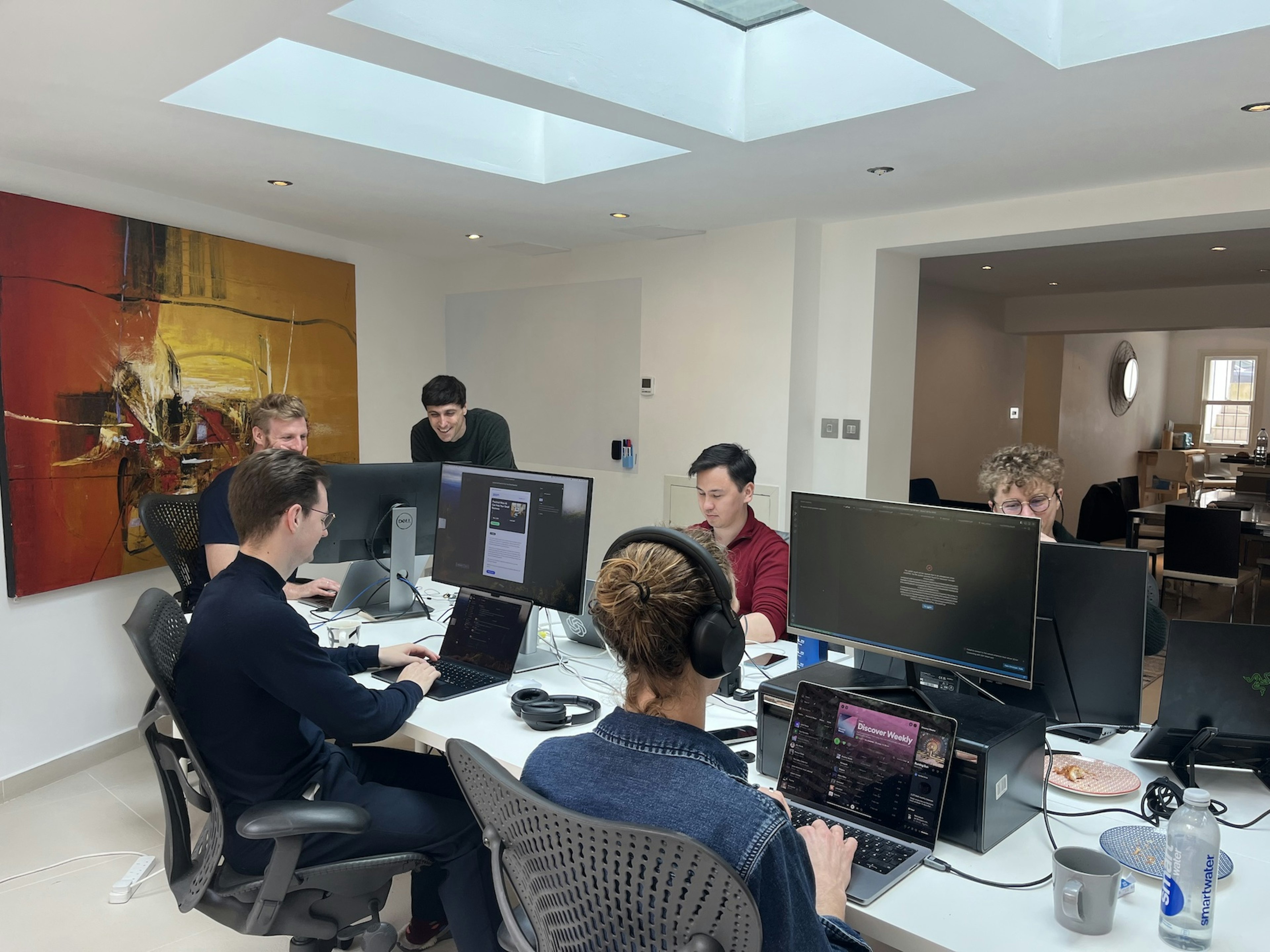 Six men sitting around a coworking space 