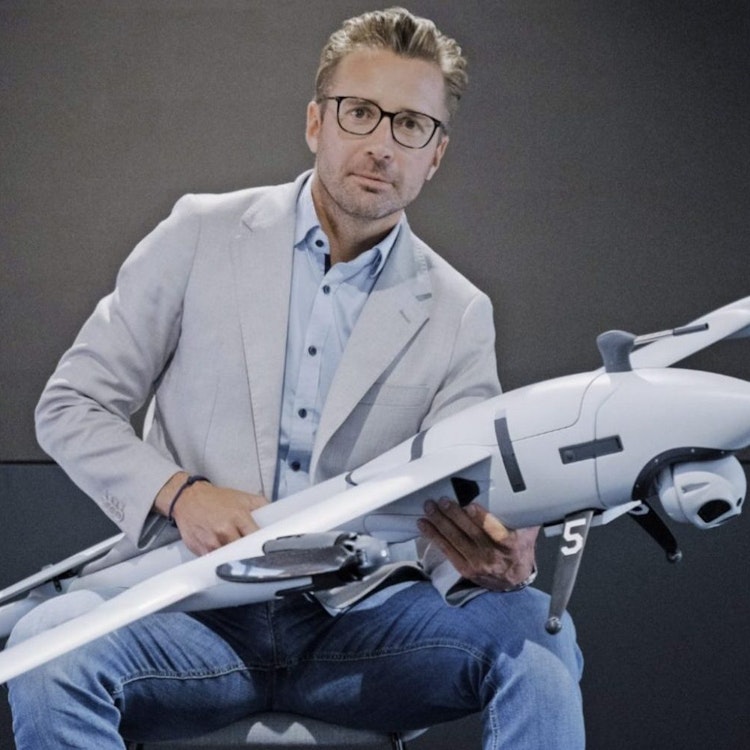 Quantum Systems and Stark founder Florian Seibel sits holding a drone.