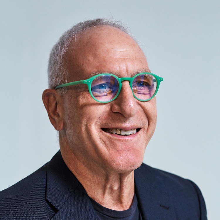 A headshot of Rob Bier who is smiling and wearing green glasses and a black tshirt.