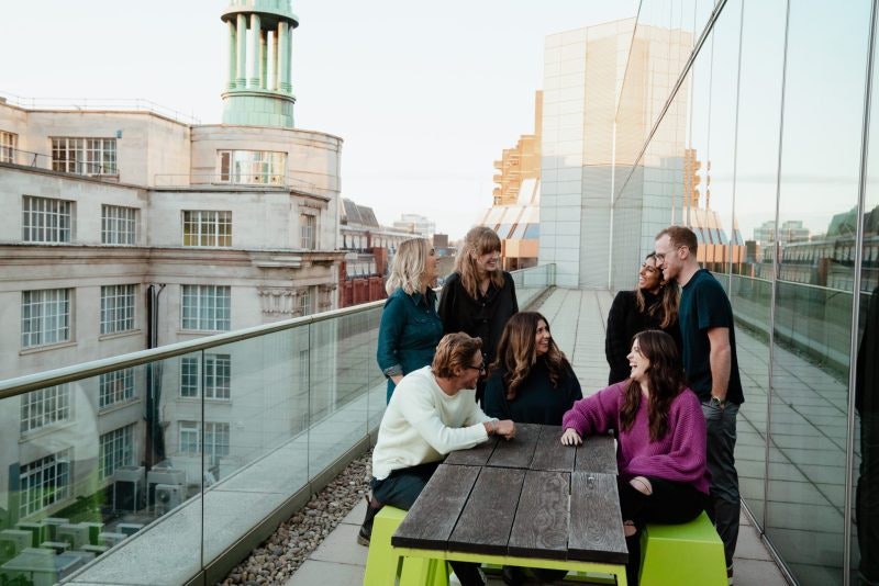 Some of the Octopus Ventures team sat at a bench outside, on a terrace.