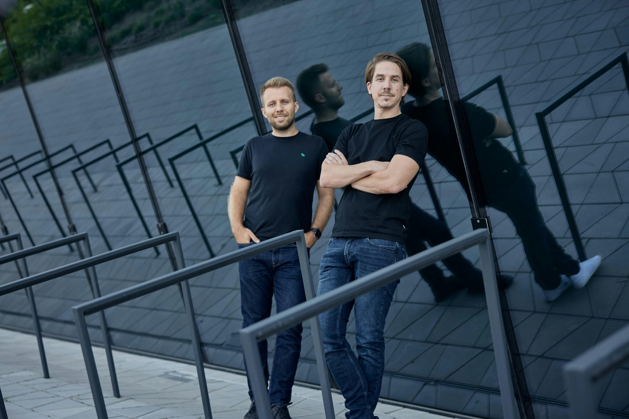 Eversnyc cofounders Zoltan Patai and Wolfgang Wörner leaning against a window outside.