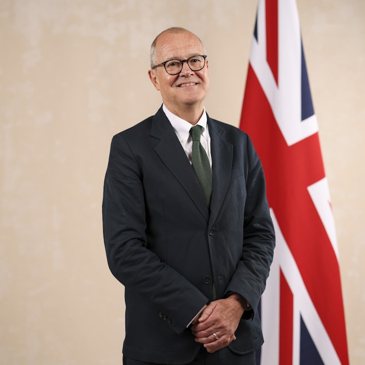 UK science minister Patrick Vallance standing beside a union jack.