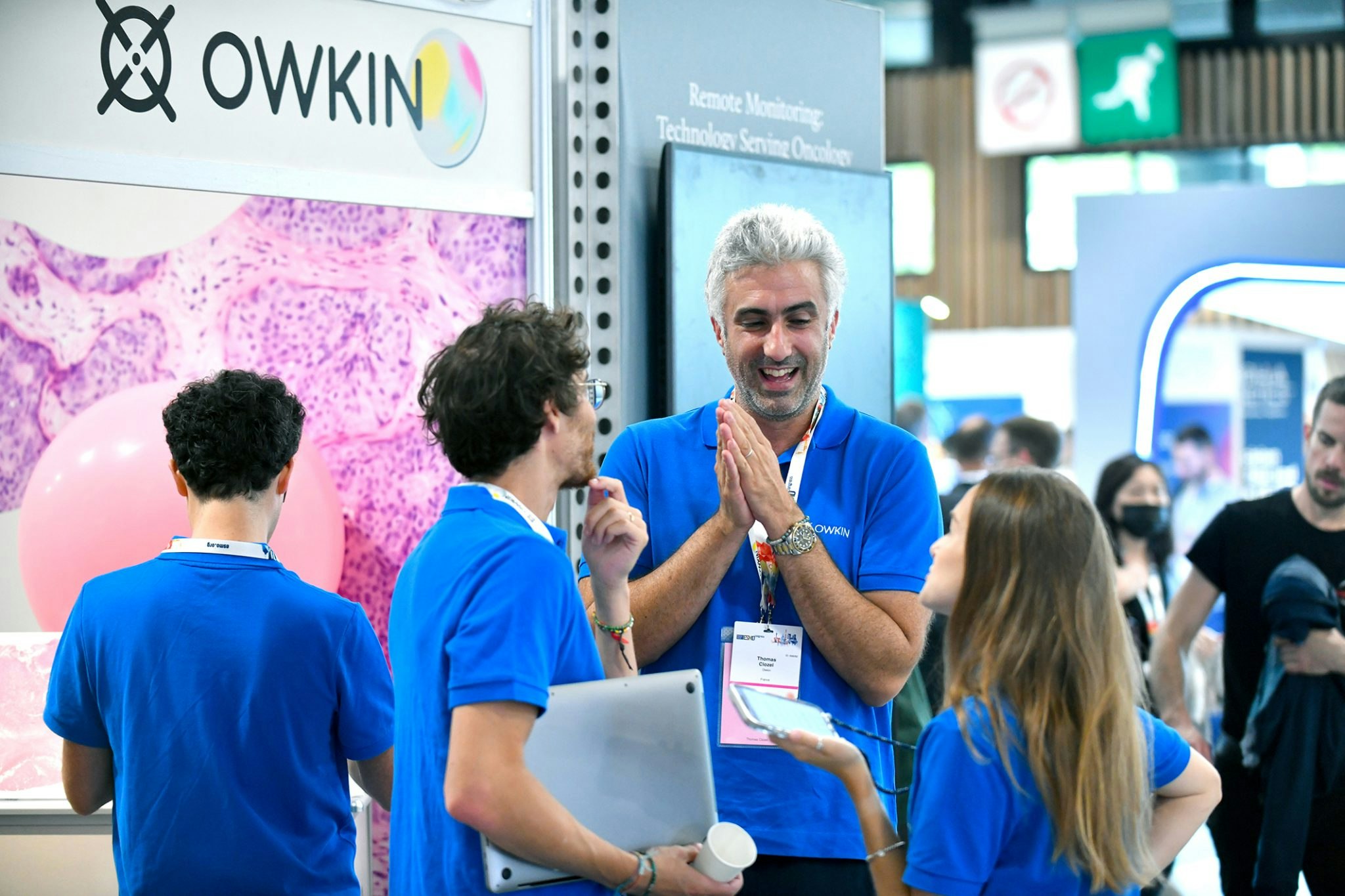 A picture of Owkin's founder and CEO Thomas Clozel talking with two colleagues at a conference