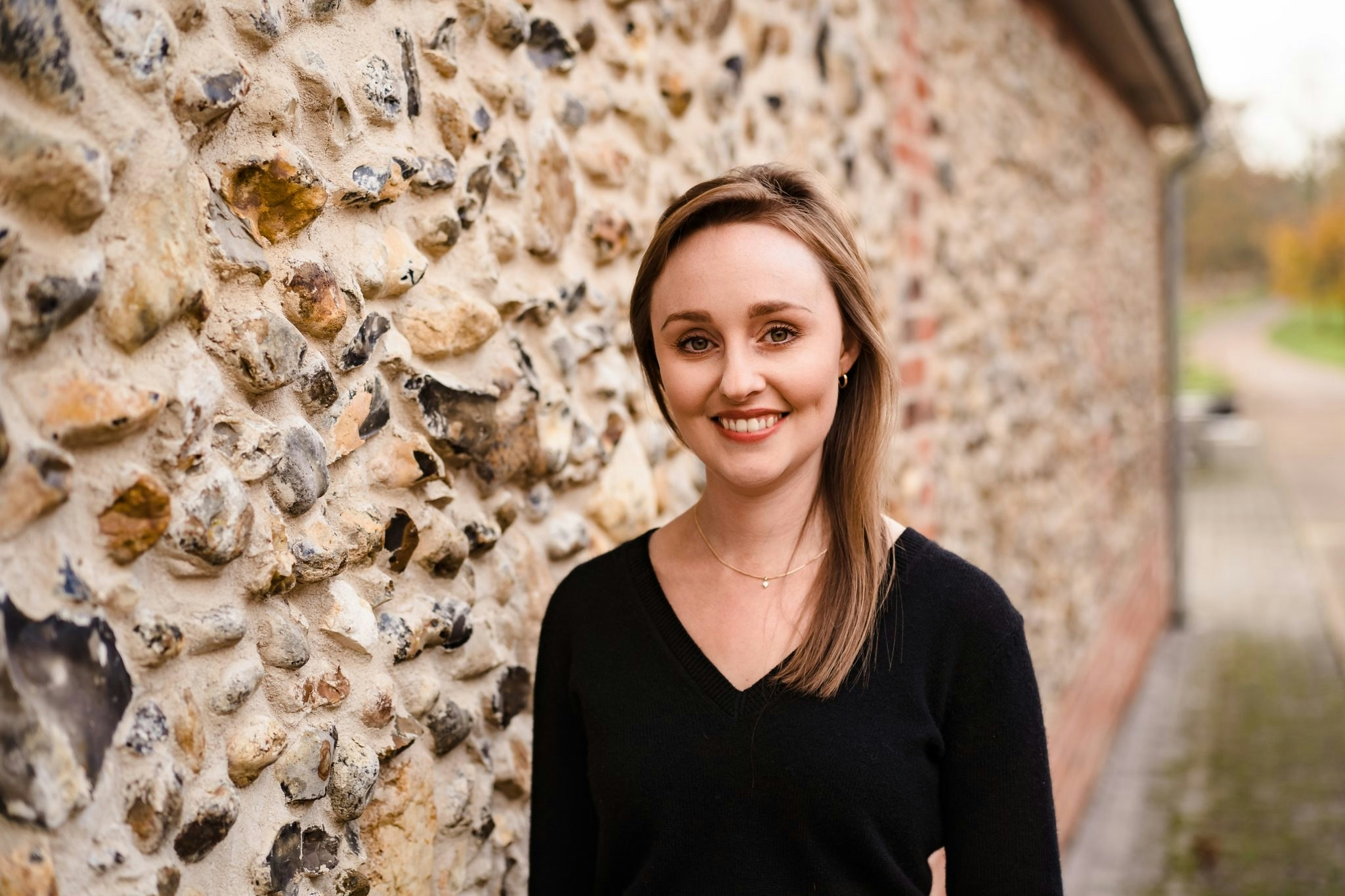 Amy Rushby portrait, stood next to a brick wall
